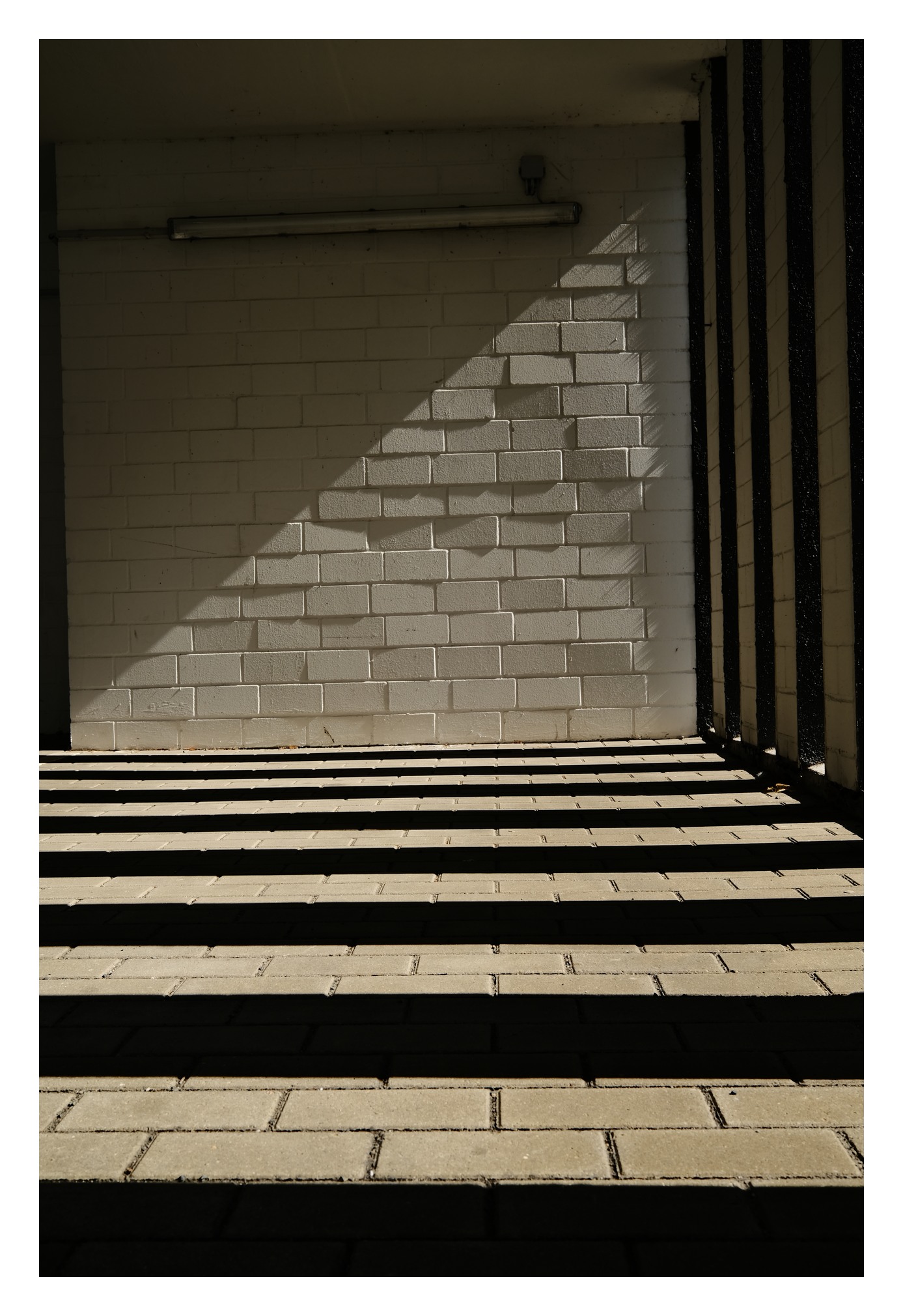 Geometrische Licht- und Schattenbänder auf Mauer und Boden